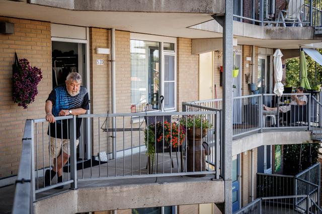 Evert Heinhuis bij zijn woning, met onder hem een galerijverdieping die inmiddels volledig leegstaat.