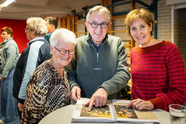 Els Straver, Lammie Dolsma en Minus Aalderink bladeren door een fotoboek over vijftig jaar Living Lord Singers.