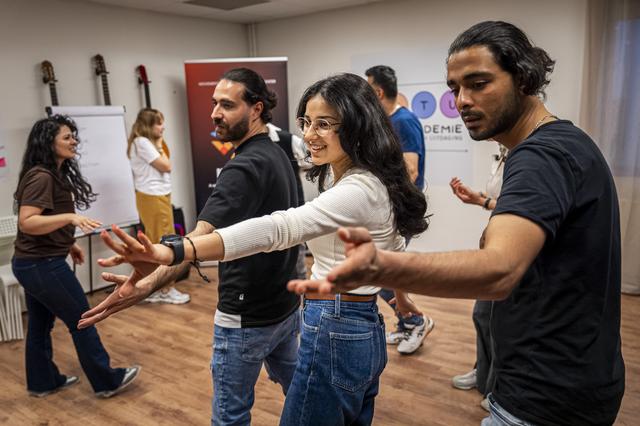 Eliana uit Syrië (midden) werkt met haar groepsgenoten aan een dans die ze in tien minuten maken en instuderen.