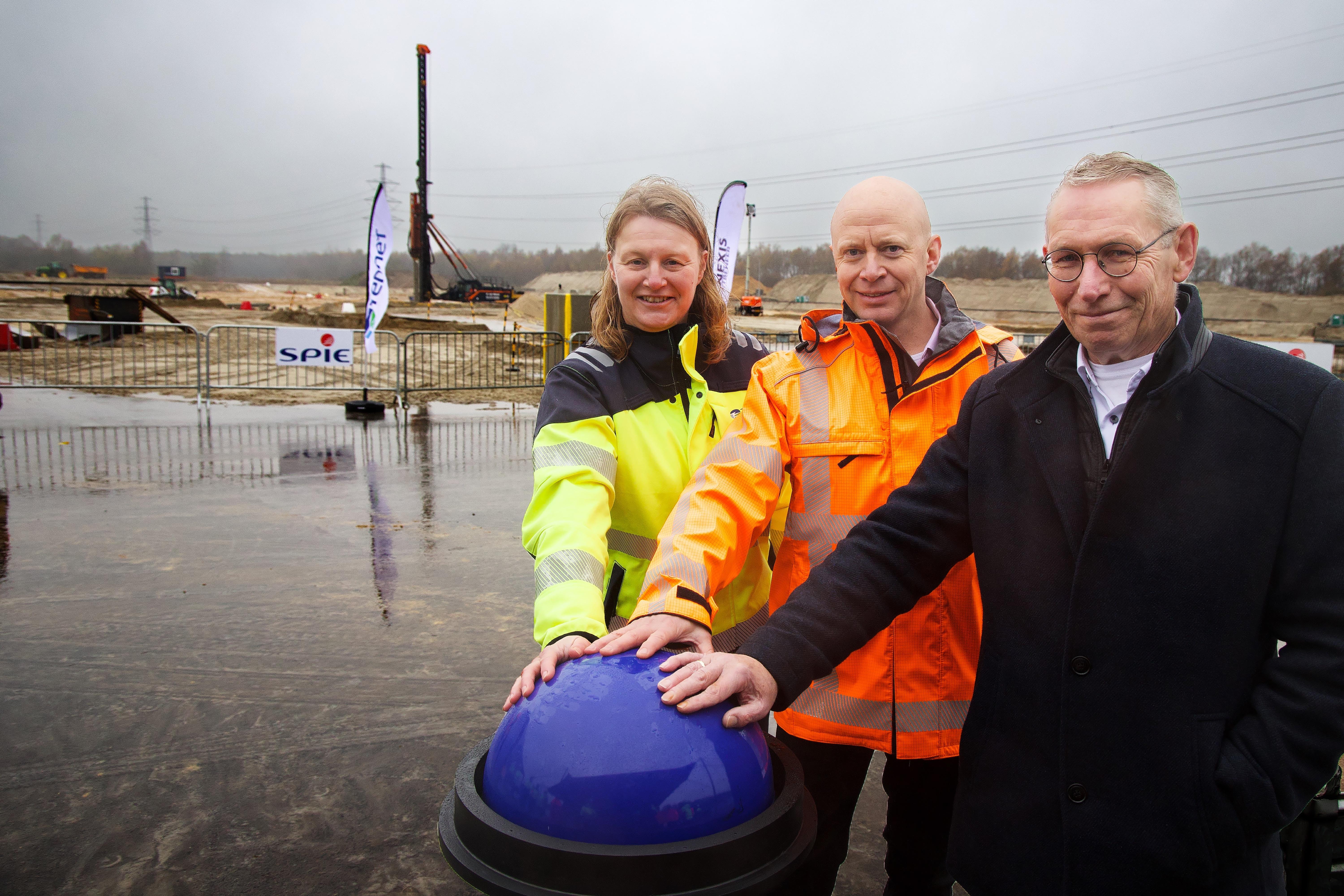 Op symbolische wijze zetten Anja Wanningen van TenneT, Jan Willem Janse van Enexis en wethouder Jan Schipper de hei-installatie in werking voor de duizendste heipaal van het elektriciteitsstation in Wijster.