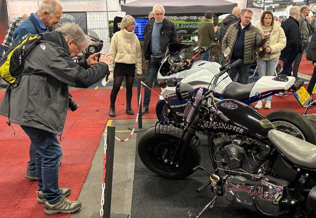 Ben (met camera) en Aldo kijken met grote interesse naar een witte BMW 6-cilinder.