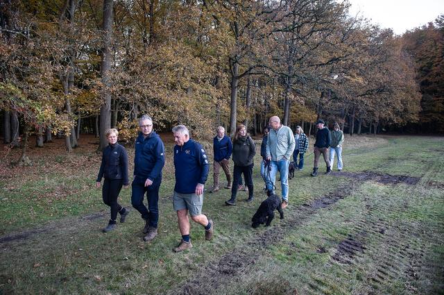 Menno Klok, vooraan met korte broek, wandelt met het behandelteam van zijn zoon in het bos bij Annen. Links zijn vrouw Gea.
