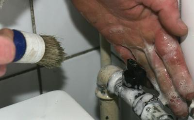 Beeld van een installateur die een vaatwasser aansluit ter illustratie.