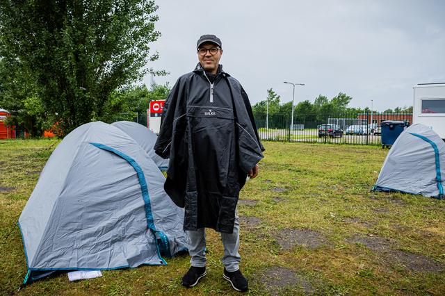 De Algerijnse Aziz (51) in de regencape die is uitgedeeld door het Rode Kruis. 