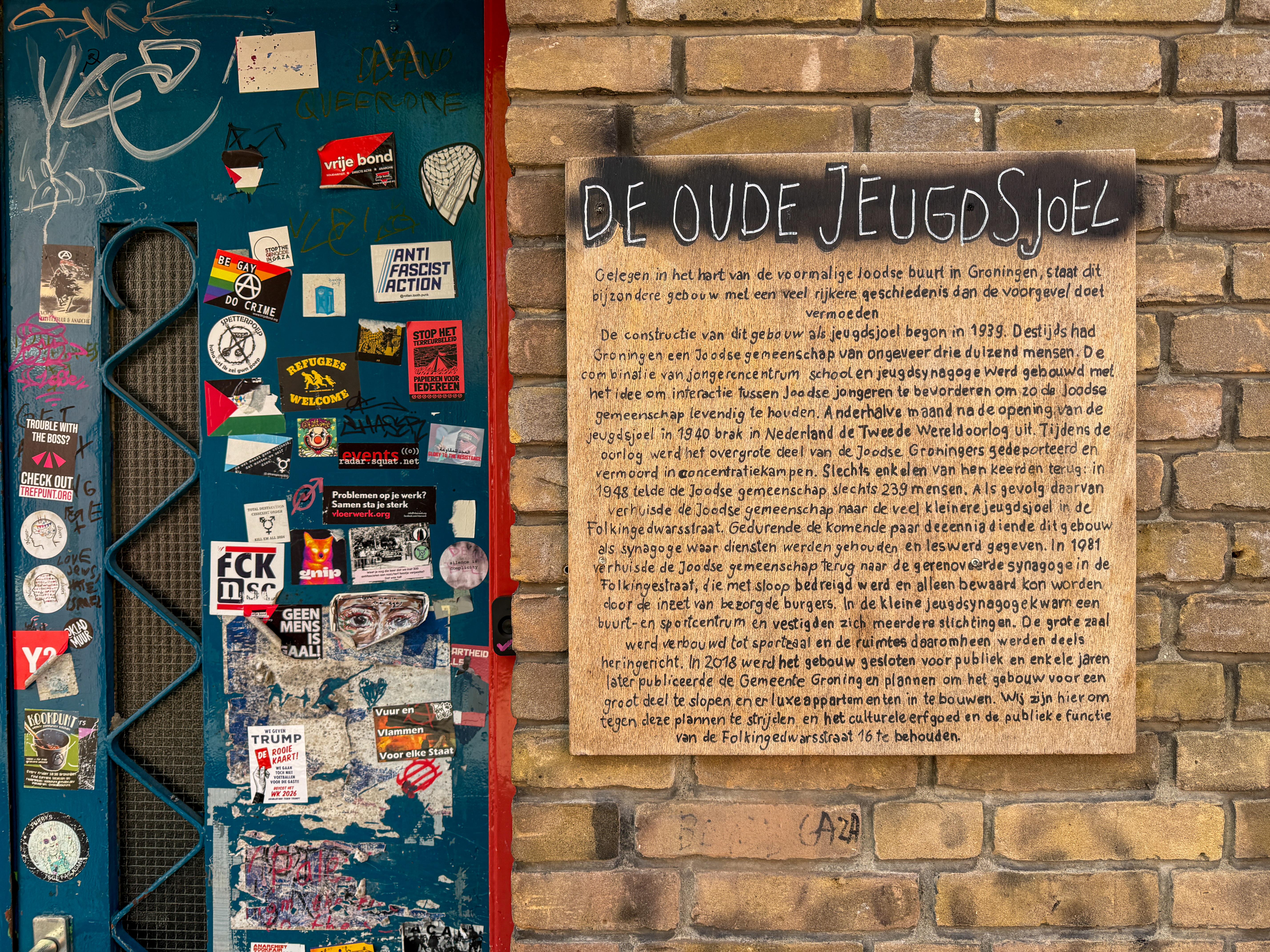 De krakers hebben naast de voordeur een bord opgehangen met de historie van de jeugdsynagoge.