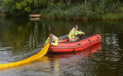 Medewerkers van de NAM ruimen begin oktober de vervuiling in het afwateringskanaal op. Foto: Aarchief DvhN