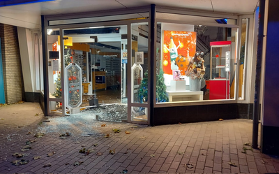 De ingeslagen en deels geplunderde etalage van opticien Greving en Greving.