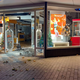 De ingeslagen en deels geplunderde etalage van opticien Greving en Greving.