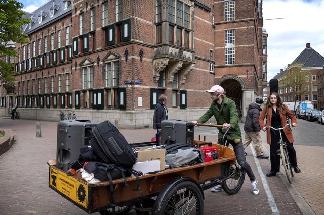 Iris en Fedde van de band Waterleaf komen met de bakfiets met apparatuur aan bij het Provinciehuis.