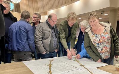 Sita (r.) en haar man Hendrik-Jan van Faassen (grijze jas) bekijken de schetsen samen met plaatsgenoten.