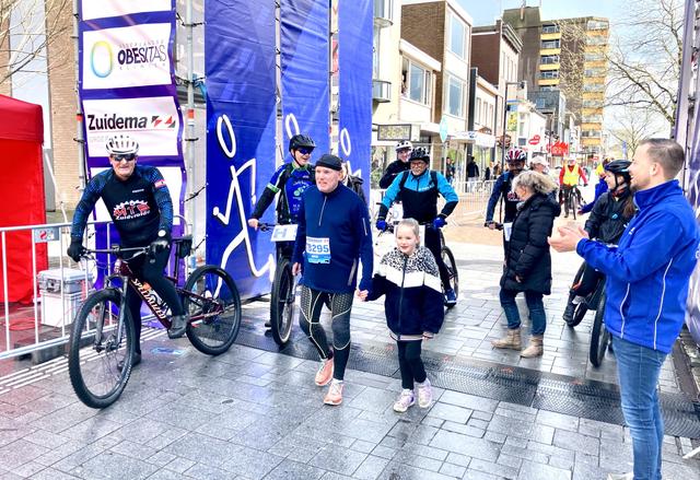 Arie was toch echt de laatste hardloper die zondag over de finish kwam. Hier samen met zijn kleindochter.