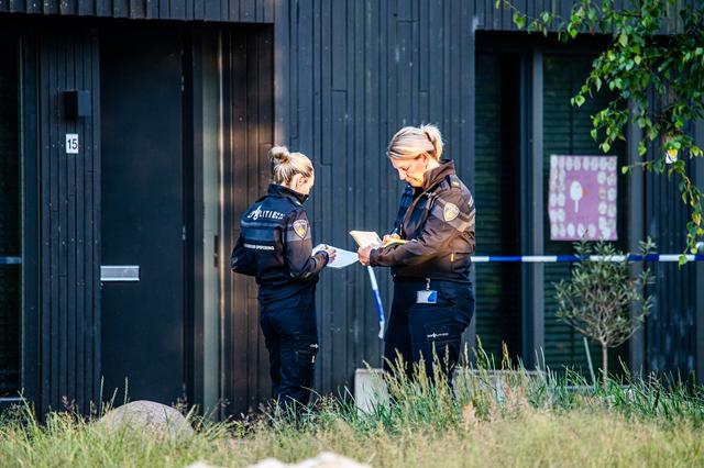 De politie doet onderzoek bij de woning waar een echtpaar gedood werd.
