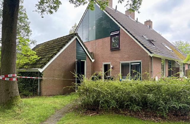 Roodwitte linten bij de woning houden nieuwsgierigen op afstand. Binnen doen forensisch specialisten onderzoek.