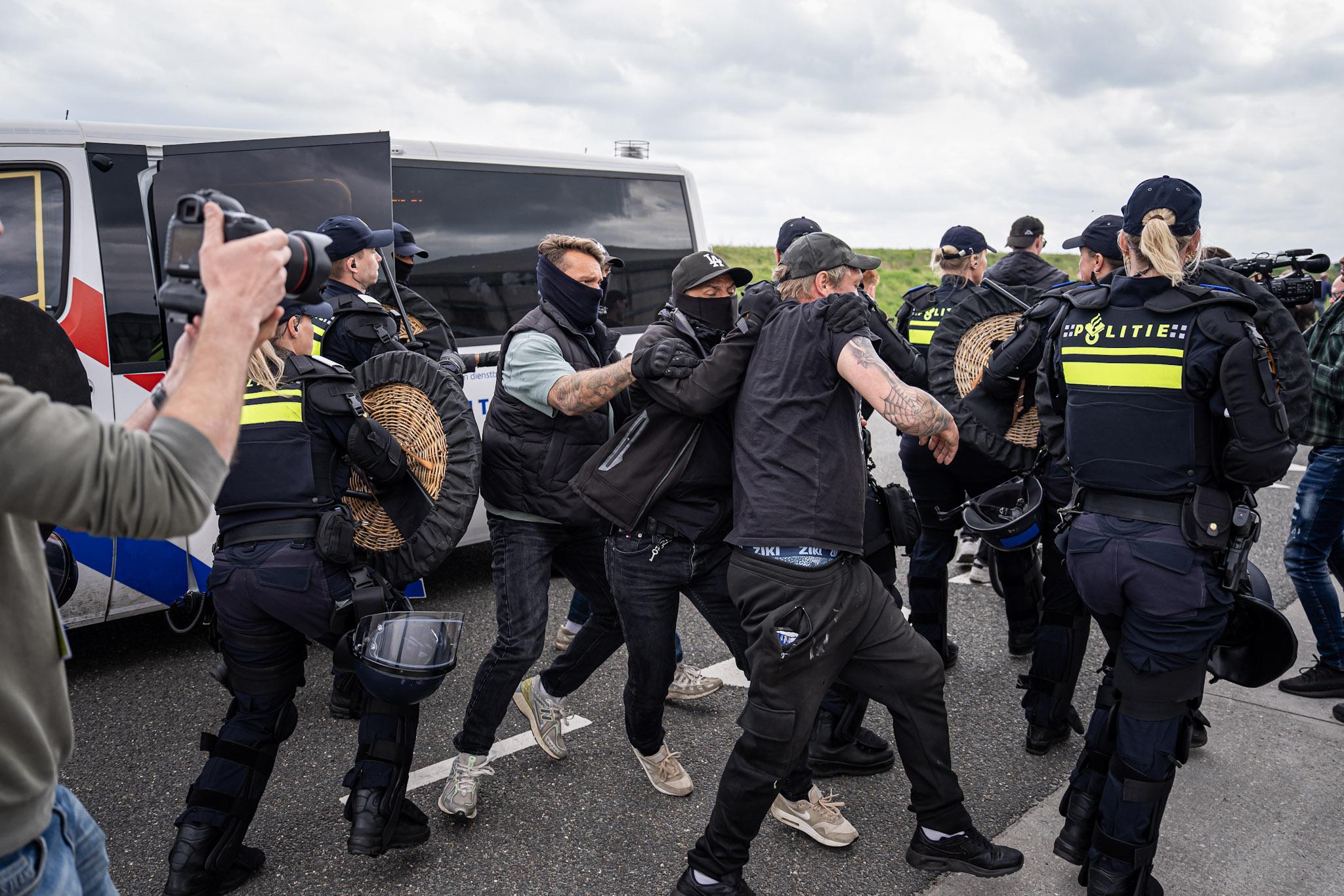 Een anti-azc demonstrant wordt aangehouden. De politie sleept hem een busje in op de Ter Apelervenen. 