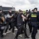 Een anti-azc demonstrant wordt aangehouden. De politie sleept hem een busje in op de Ter Apelervenen. 