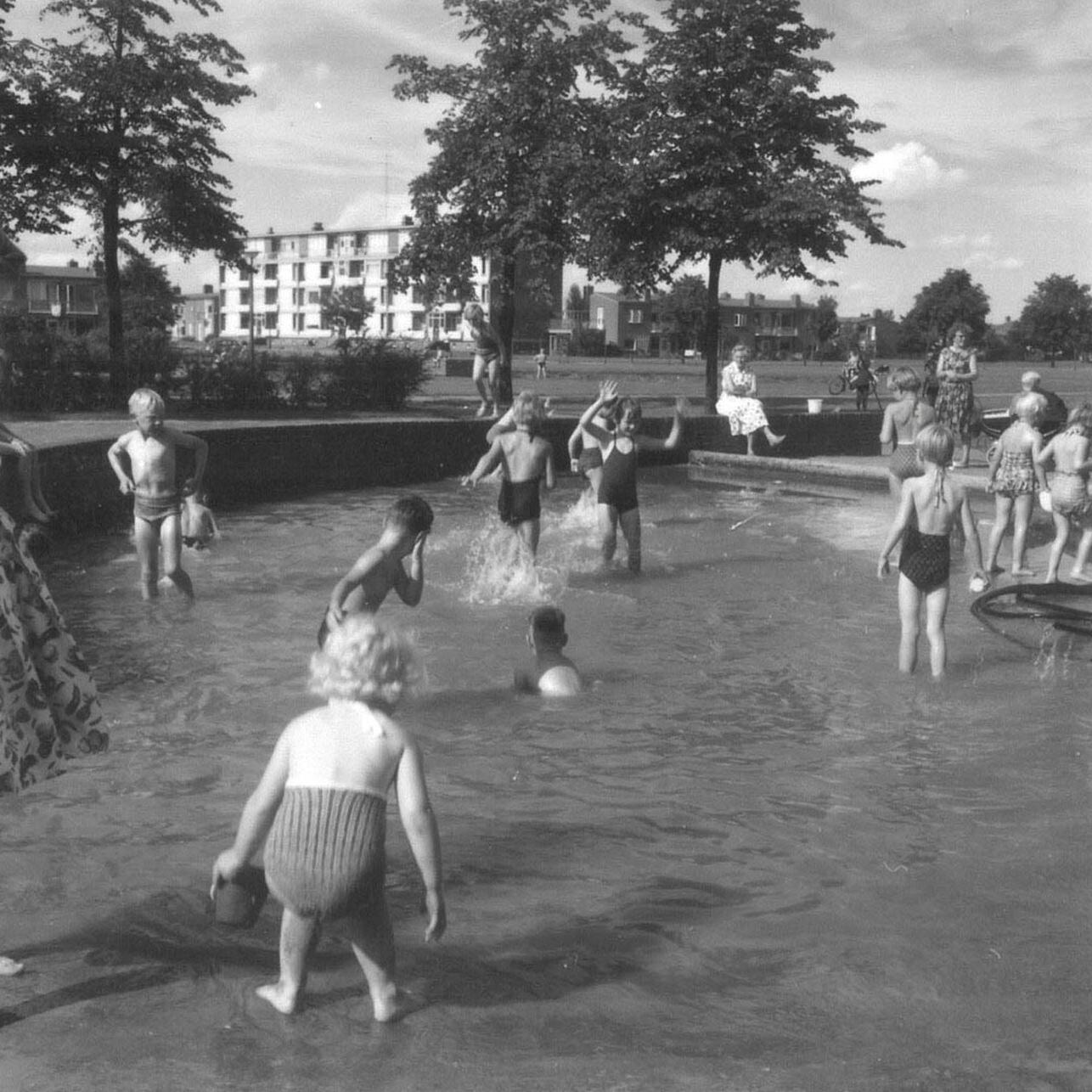 Spelen in het wijkpark Emmermeer. Op achtergrond een van de vijf Nicolai-flats.