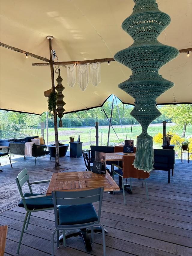 De inrichting op het overdekte terras geeft een gezellige buiten-huiskamer-vibe.