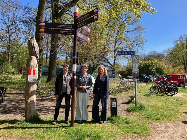 Albert Broekman (Recreatieschap Drenthe), gedeputeerde Willemien Meeuwissen en Marketing Drenthe-directeur Yvonne Cornax (vlnr.) bij het wandelknooppunt in Schipborg.