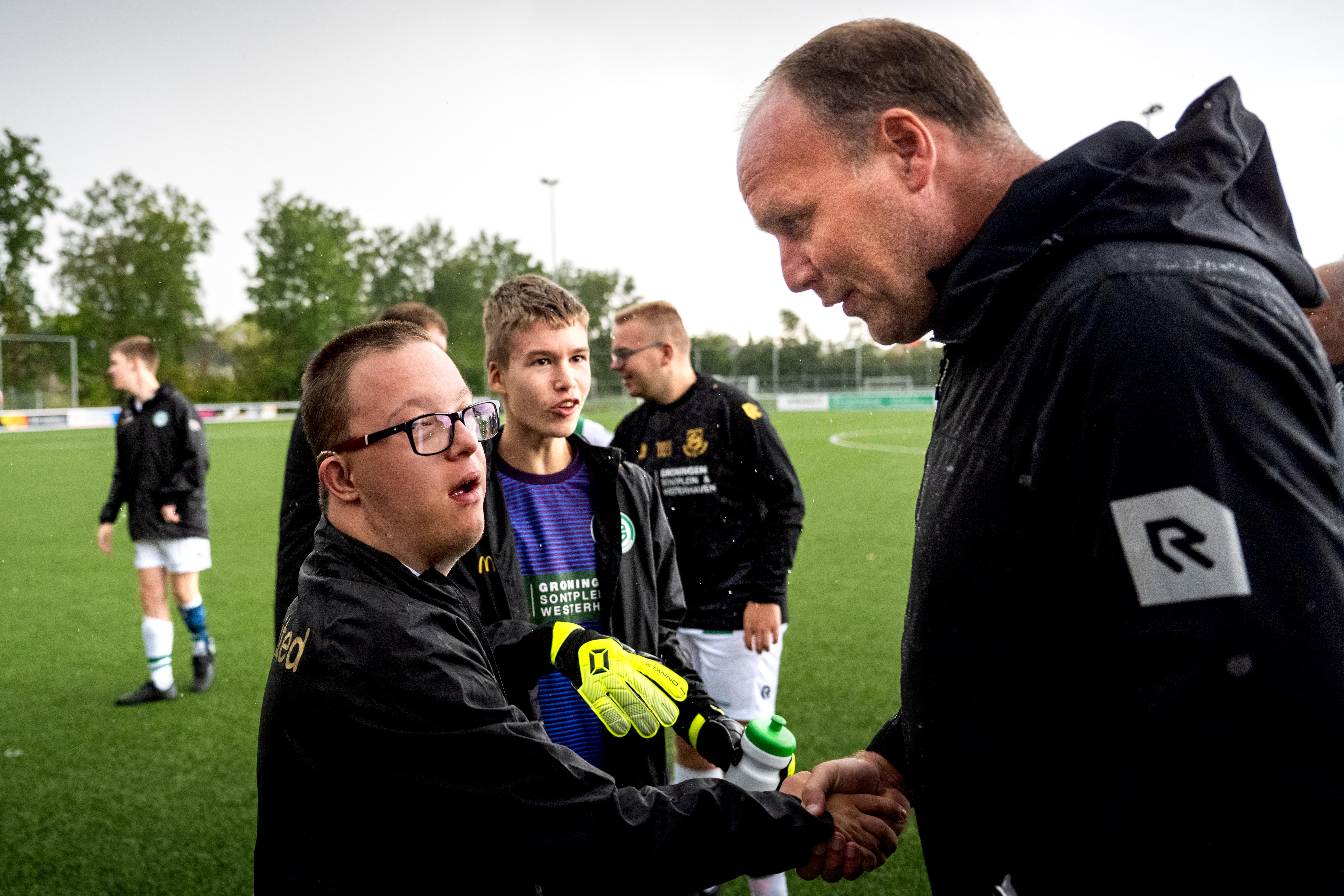 Dick Lukkien stelt zich tijdens een toernooi voor aan van zijn spelers van FC Groningen/Kids United.