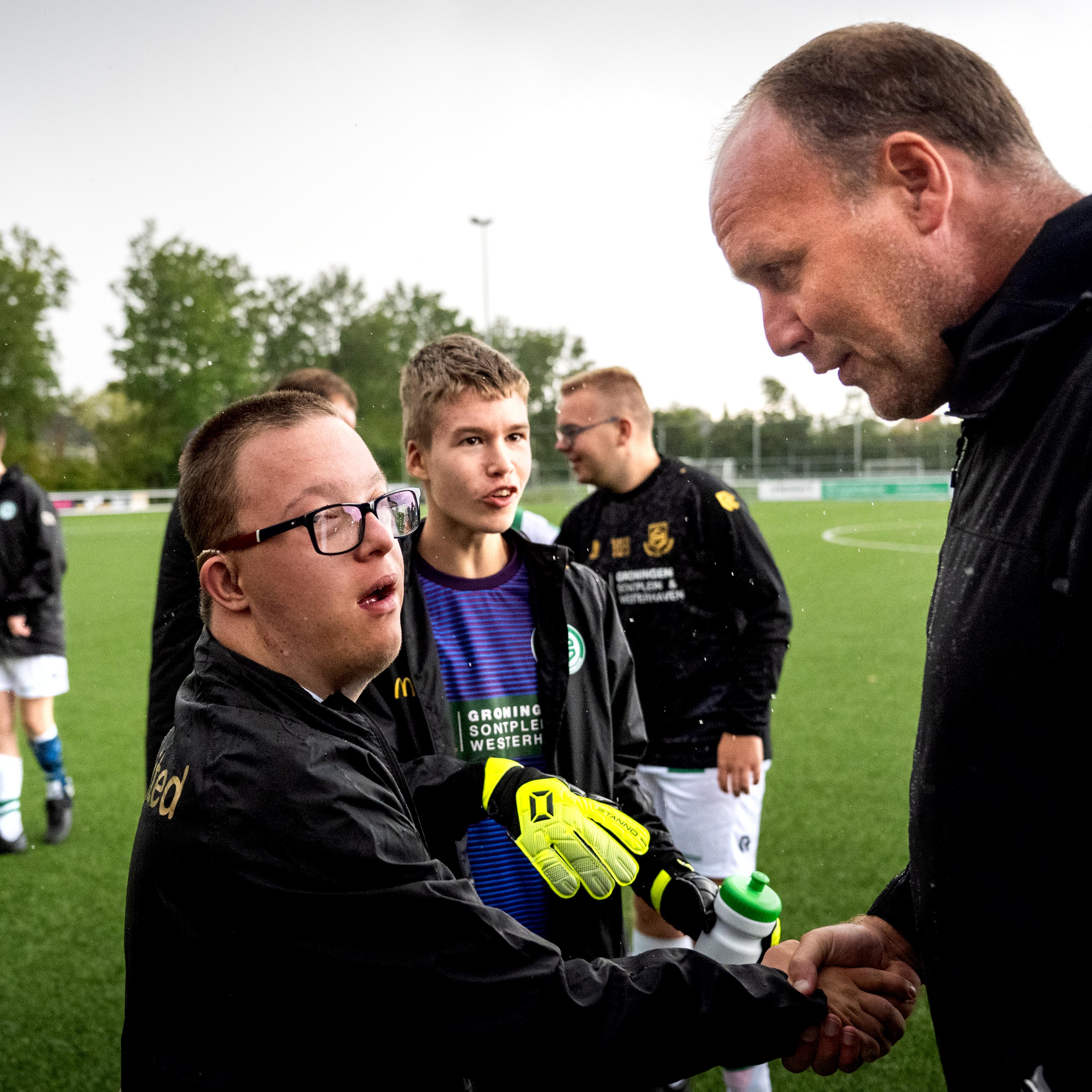 Dick Lukkien stelt zich tijdens een toernooi voor aan van zijn spelers van FC Groningen/Kids United.