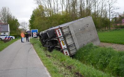 De vrachtwagen met watertanks kantelde en viel op z'n kant over de sloot.