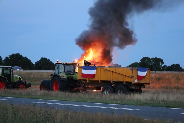 Actievoerders steken balen hooi in de brand langs de A28.