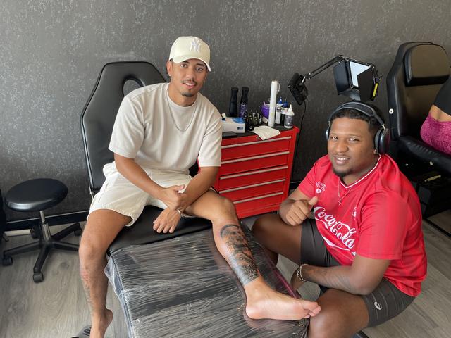 Melvin Wirjosemit en tattooshop-eigenaar Shaquille Hessen nadat de klus van uren erop zit. ,,Niet zomaar een tatoeage."