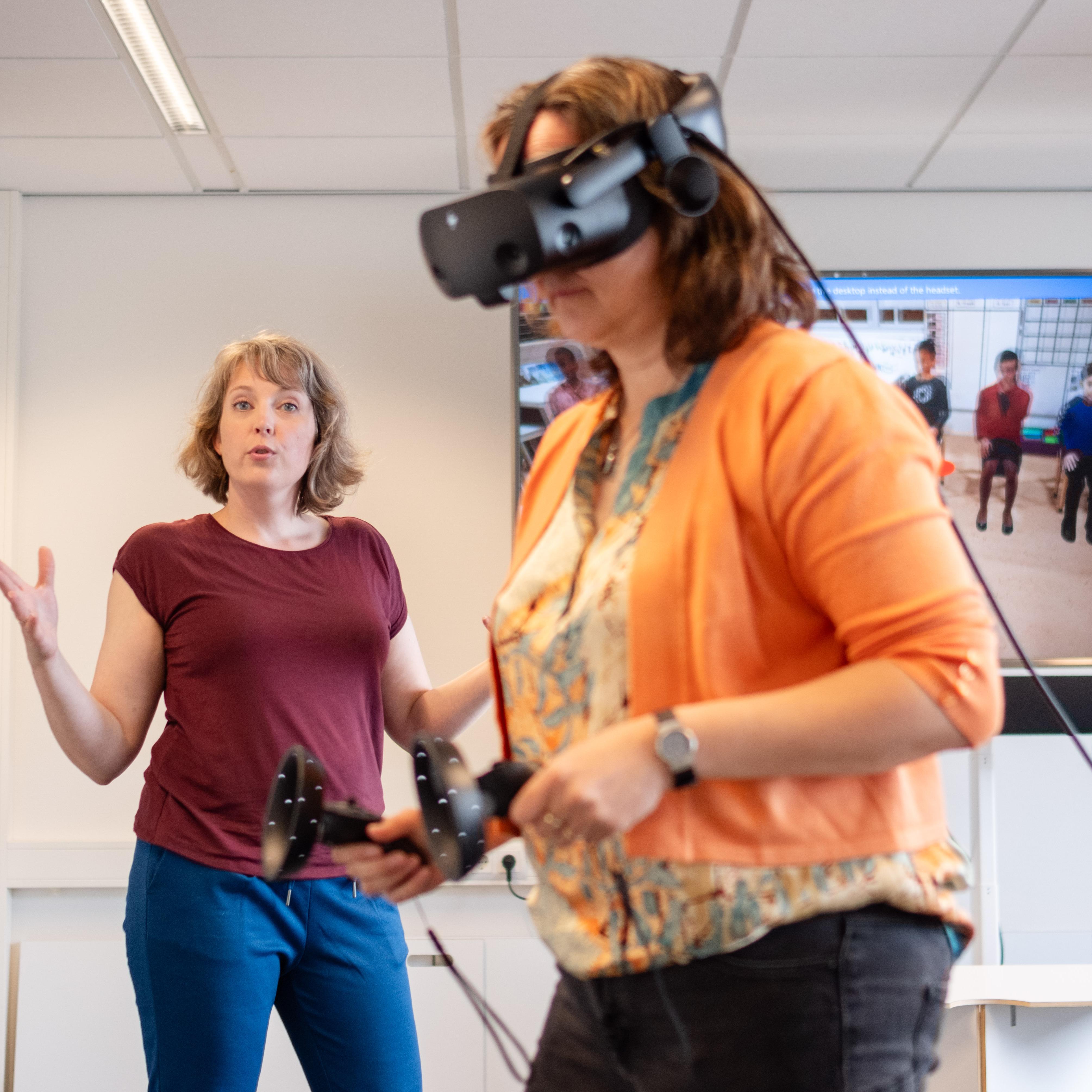 Jolien Mouw (links) en Marjon Fokkens-Bruinsma (rechts) laten zien hoe de virtual reality klas eruitziet. 