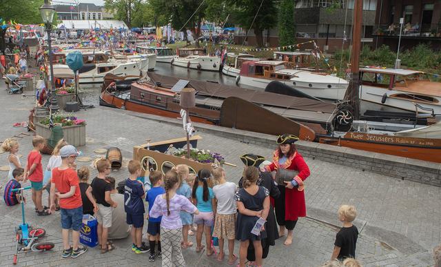 Kinderen worden vermaakt door piraten met een schat. Op de achtergrond het skûtsje De Twee Gezusters van Ruurd en Ann IJpelaar.