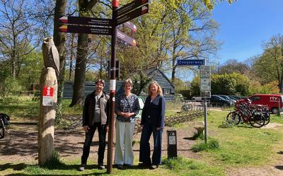 Albert Broekman (Recreatieschap Drenthe), gedeputeerde Willemien Meeuwissen en Marketing Drenthe-directeur Yvonne Cornax (vlnr.) bij het wandelknooppunt in Schipborg.