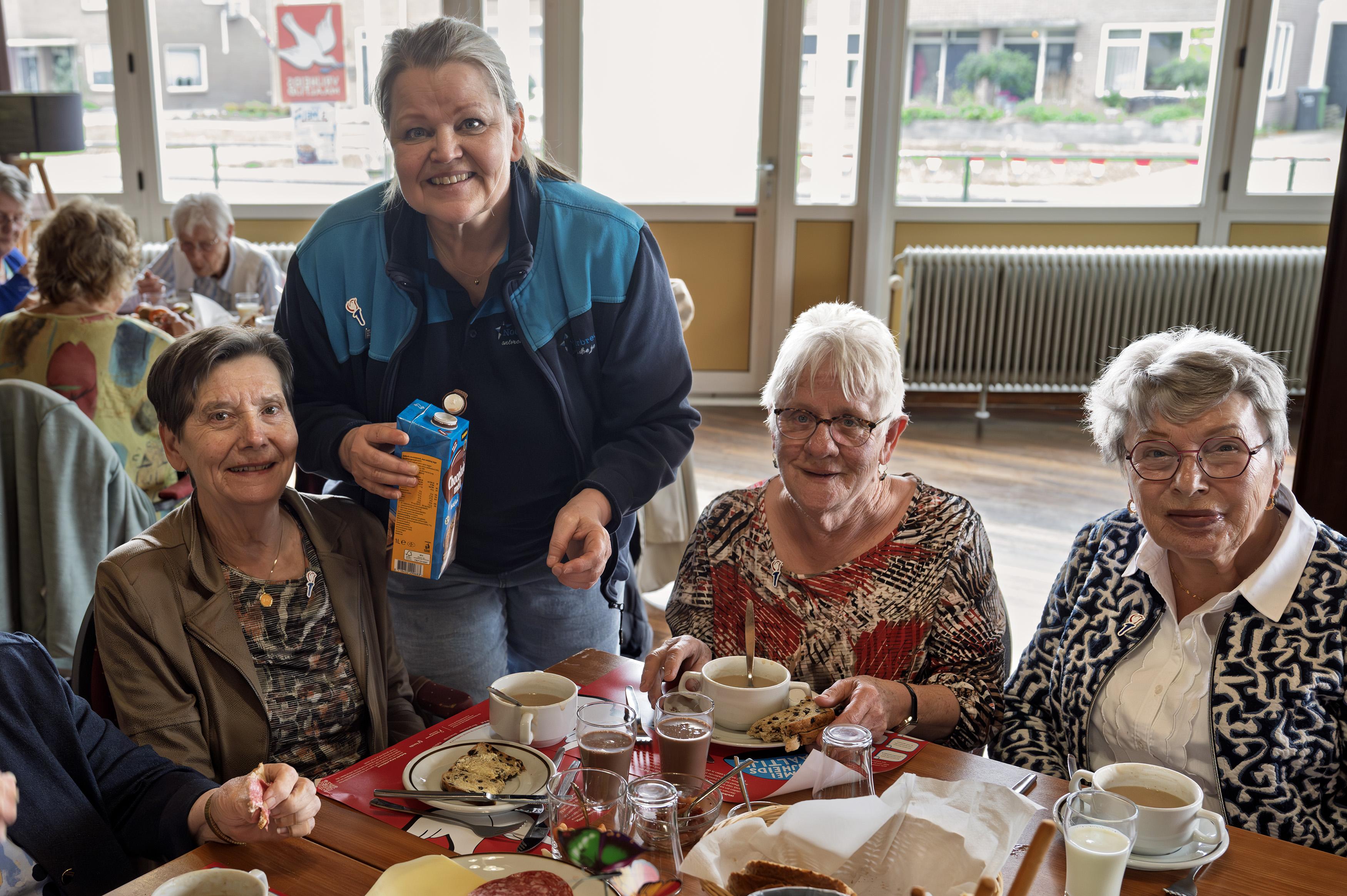 Fetsje, Joke en Jannie aan de vrijheidssoep in Klazienaveen. Beheerder Anja Bijen van de Noorderbreedte schenkt drinken in. 