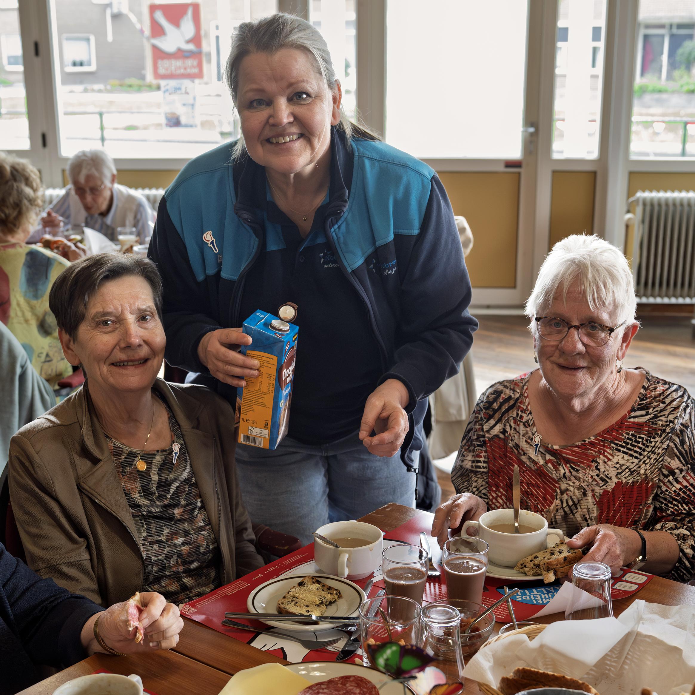 Fetsje, Joke en Jannie aan de vrijheidssoep in Klazienaveen. Beheerder Anja Bijen van de Noorderbreedte schenkt drinken in. 