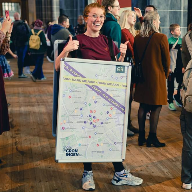 Manon Prins van Groener Groningen draagt de plattegrond als billboard bij zich. 