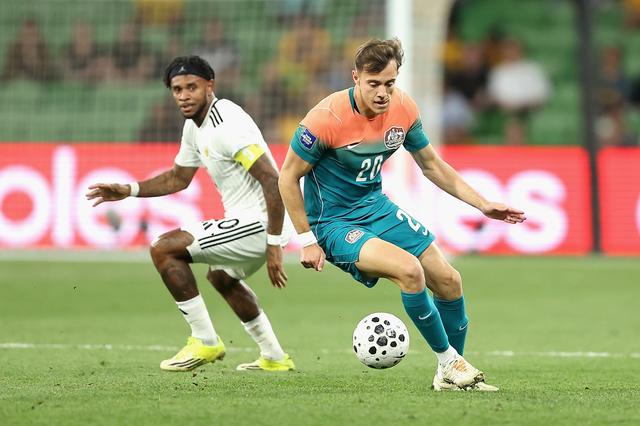 Paul Okon draait namens Australië weg bij aanvoerder Leandro Bacuna van Curaçao. 
