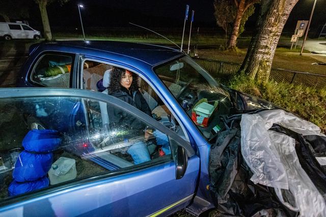 Nadia Slimi wacht in haar auto totdat mensen noodgedwongen buiten moeten blijven op het voorterrein van het aanmeldcentrum in Ter Apel. Ze heeft tenten en slaapzakken bij zich.