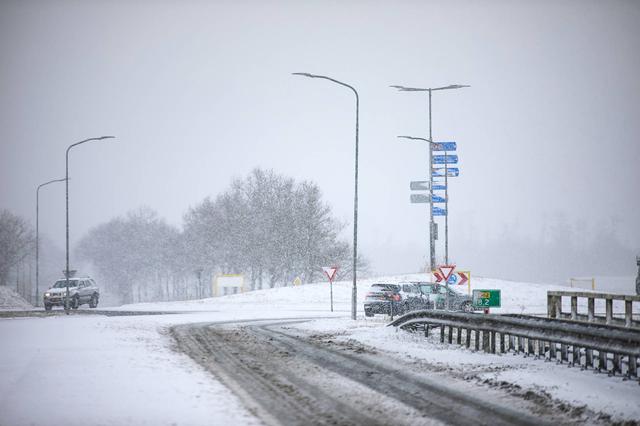 Automobilisten ploeteren door de sneeuw bij Scheemda.