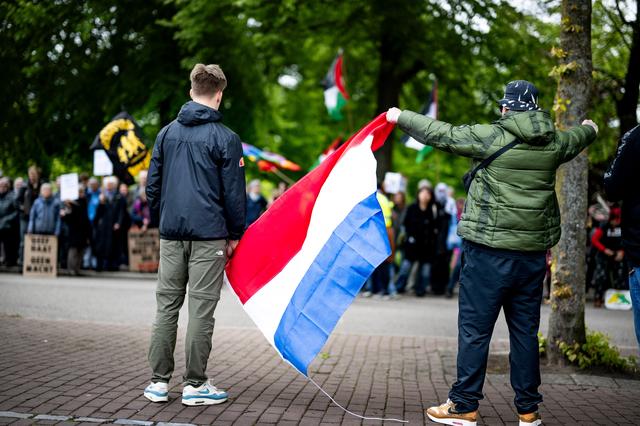Deelnemers aan het Nationaal Protest op de Ossenmarkt staan tegenover een linke tegendemonstratie.