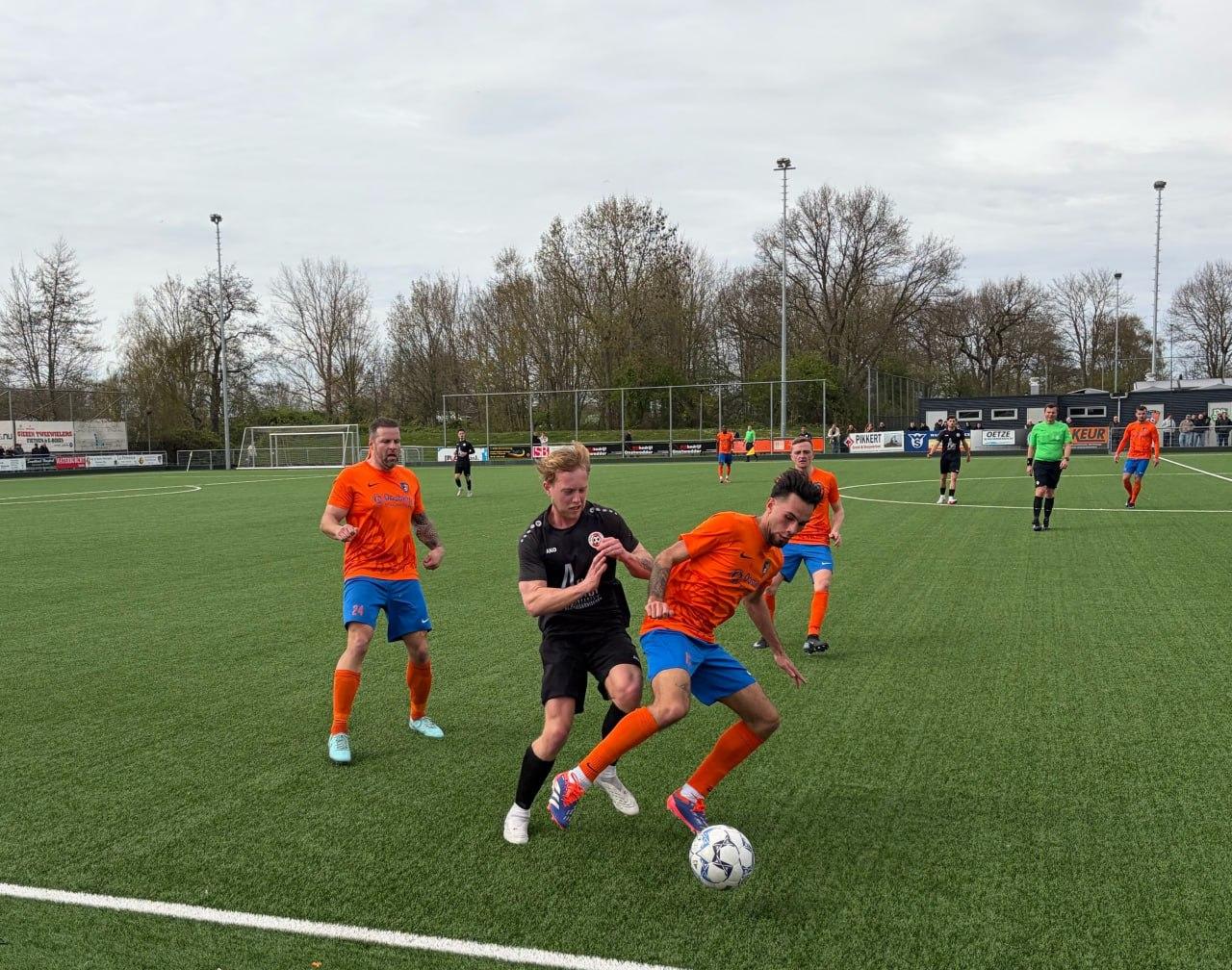  Joel Zweerink (HZVV) en Tyrell Strik (PKC'83) verwikkeld in een duel om de bal..