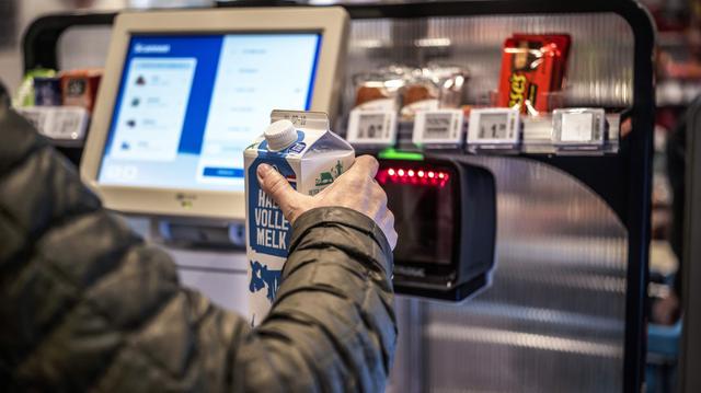 Vrouw scant de boodschappen bij een zelfscankassa van een supermarkt. 