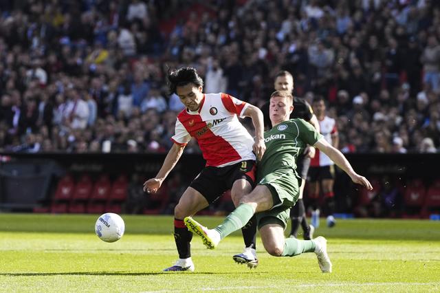 Dies Janse probeer Ayase Ueda, de topscorer van de eredivisie, af te stoppen. 