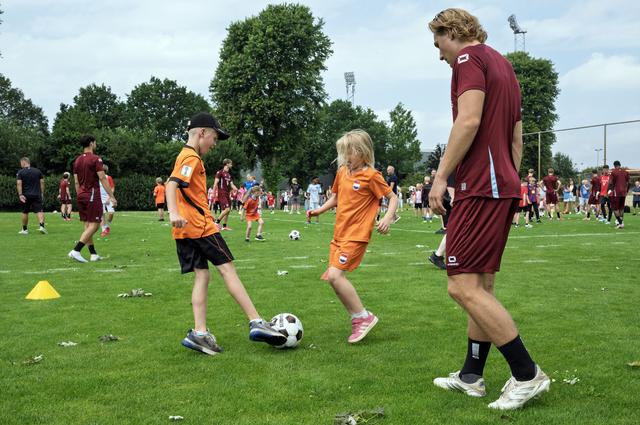 Jonge fans van FC Emmen (en Oranje) proberen elkaar en Peter Quispel te dollen. 