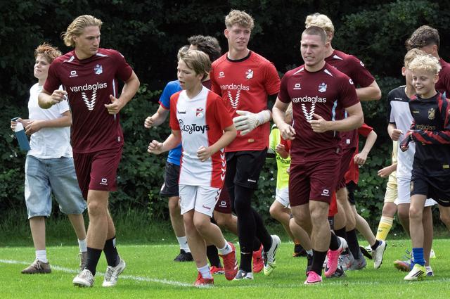 Warming-up samen met de spelers. Sommigen op halve kracht, anderen voluit. 