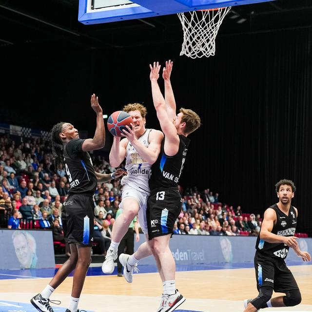 Austin Luke van Donar baant zich tussen Zwollenaren Devin Whitfield en Boyd van der Vuurst een weg naar de basket. 