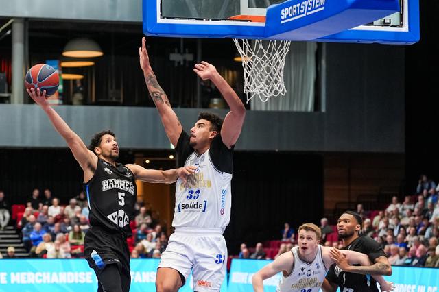 Voormalig Donar-speler Leon Williams wordt verdedigd door Damian Forrest van Donar.
