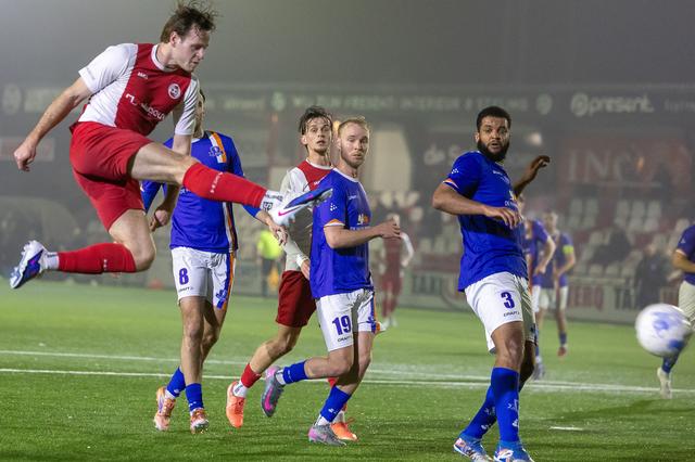 HZVV'er Yoran Popovic (links) haalt verwoestend uit en maakt de tweede goal voor de Hoogeveense ploeg. De Buitenpost-spelers Wolter-Klaas Laanstra en Iloba Achuna (rechts) kunnen alleen maar toekijken.