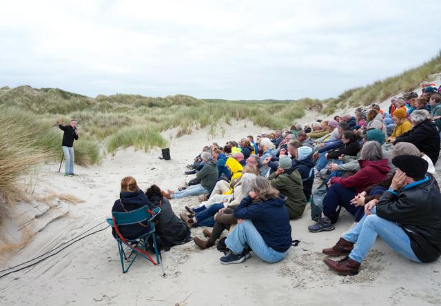 Dolf Jansen in een duinpan op Terschelling, plus publiek.