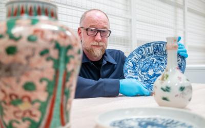 Directeur Eelco van der Lingen tussen de gerestaureerde objecten in het depot.