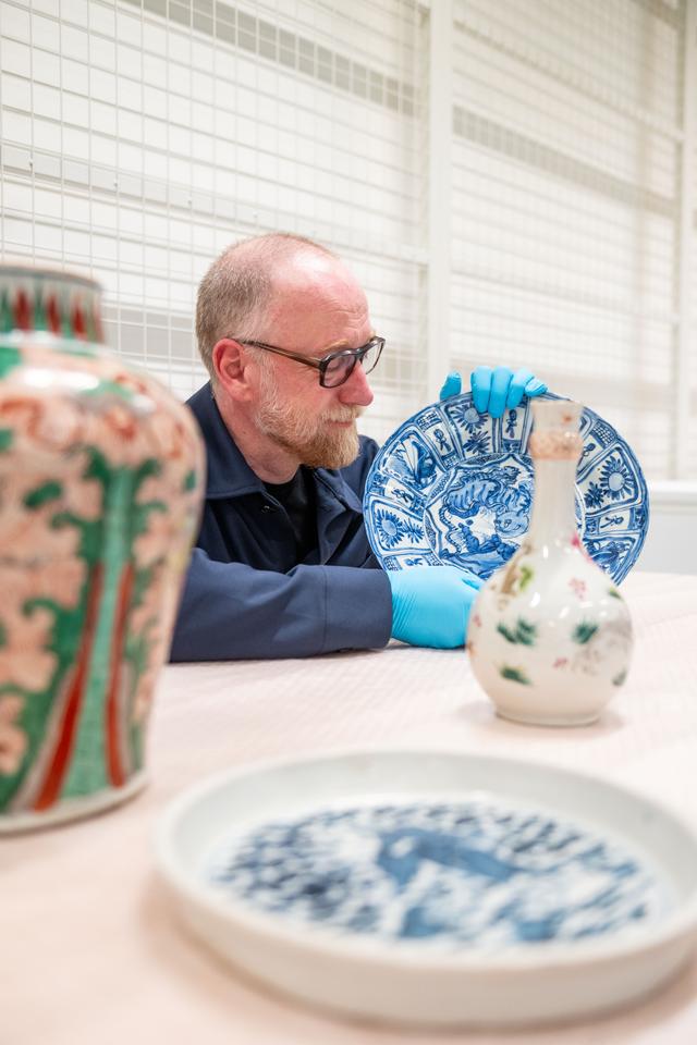 Directeur Eelco van der Lingen tussen de gerestaureerde objecten in het depot.