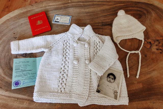 De kleertjes van Inti, samen met een foto en een paspoort, waarmee ze als baby aankwam op Schiphol. 