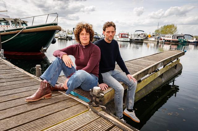 Inge van der Riet (48) en Kris van der Riet (45) op de steiger bij Alphen aan de Maas, de vaste ligplaats van de Najade (helemaal links in beeld).